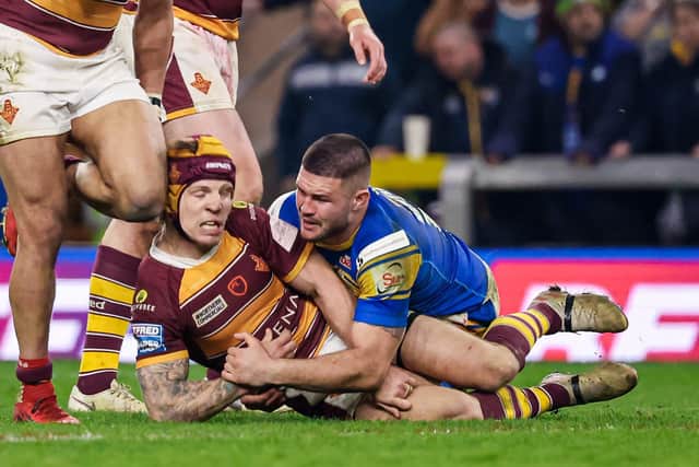 Huddersfield's Theo Fages is tackled by Leeds Rhinos' James Bentley. Picture: Alex Whitehead/SWpix.com.