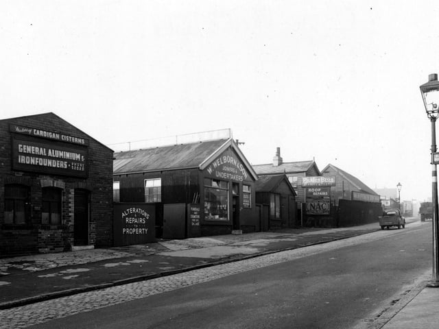 The west side of Cardigan Road in January 1954. These buildings house a number of businesses. 'Pickles Bros. (slaters) Ltd', 'S. Huggard & Son, plumbers, 'W. Welborn & Son, joiners & undertakers and 'H.J. Gill & Co. (Leeds) Ltd, cistern makers.