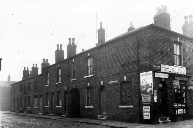 Cross Eldon Place prior to demolition in January 1959. Many of the houses have been vacated and stripped of fittings. The grocers shop is on the corner with Wordsworth Street.