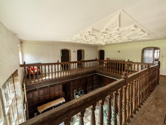 A view of the first floor landing and detailed decor to the ceiling.