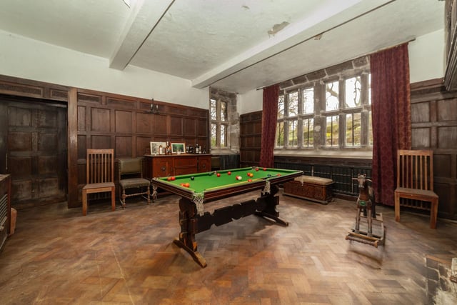 Wood panelling to the walls and parquet flooring in this games room.