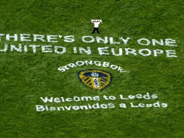 Ben Featherstone from Horsforth waves the Leeds flag above the message 'There's Only One United in Europe' in readiness for the Valencia team arriving at Leeds Bradford Airport ahead of the Champions League semi-final first leg clash at Elland Road.