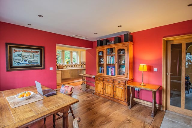 Open plan kitchen links through to the dining room with its wooden floor and spotlights.