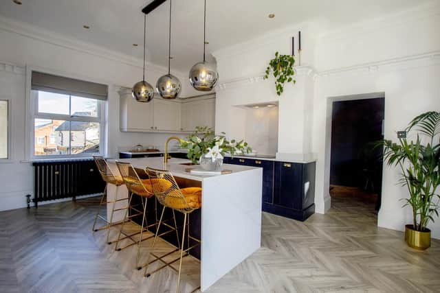 The kitchen in dark blue and white, with gold chairs from Dunelm.