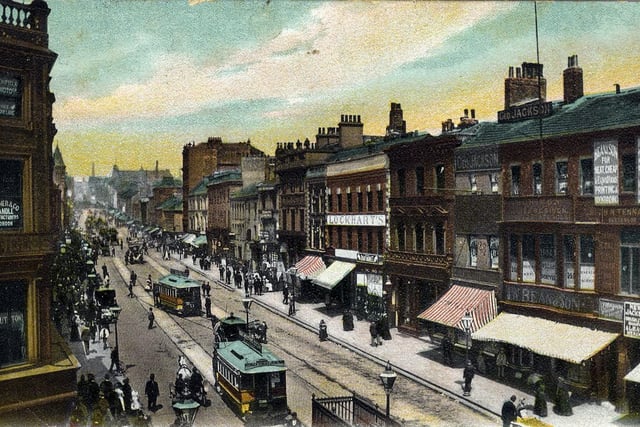 A colour-tinted postcard of Briggate looking north from the junction with Boar Lane and Duncan Street. A postal date of April 19, 1906 is stamped on the back but the picture is likely to date to a few years previous to this, since the Bull and Mouth Hotel, seen to the left of centre here, has not yet been extended upwards, as it appears in photos of circa 1904.
