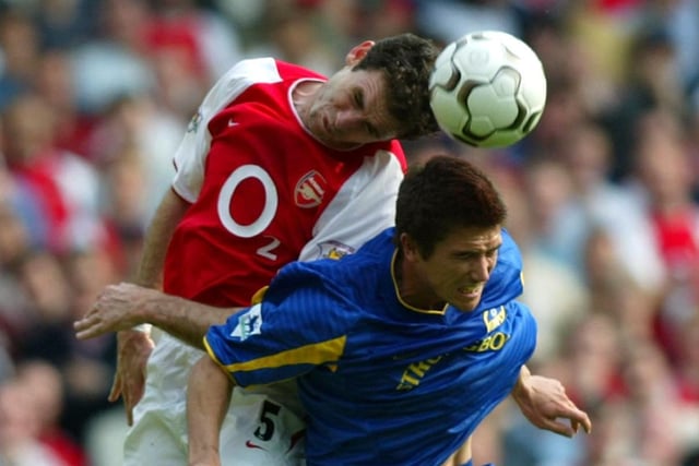 Arsenal's Martin Keown jumps above Harry Kewell.