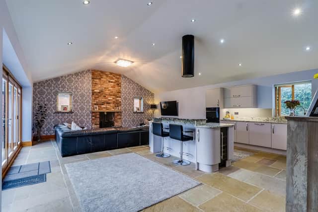 Stylish, open plan living with this sleek kitchen and feature wall to family area.