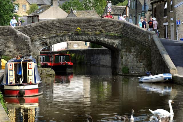 A swan and cygnets swim across the Leeds-Liverpool canal at Skipton canal basin in the summer sunshine. Photo: Gary Longbottom