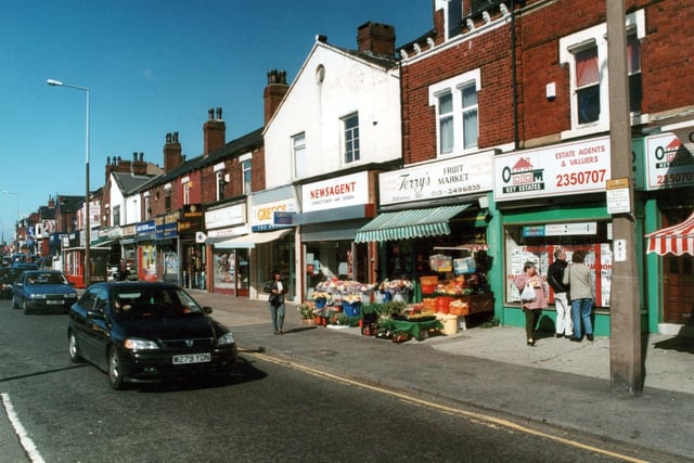 Shops on Harehills Lane in September 2000, including Jack Fulton frozen foods, Greggs Bakers and Key Estates as well as Terry's Fruit Market with fruit flowers and vegetables on display outside.