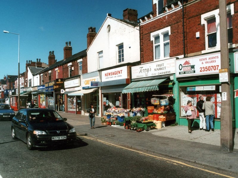 Shops on Harehills Lane in September 2000, including Jack Fulton frozen foods, Greggs Bakers and Key Estates as well as Terry's Fruit Market with fruit flowers and vegetables on display outside.