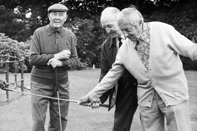 Henry Cotton (right) gives Joe Gent a few tips on how to improve his game with some tyre exercises on the first tee at Moortown in  July 1979. He is watched by the former British Amateur champion Alex Kyle.