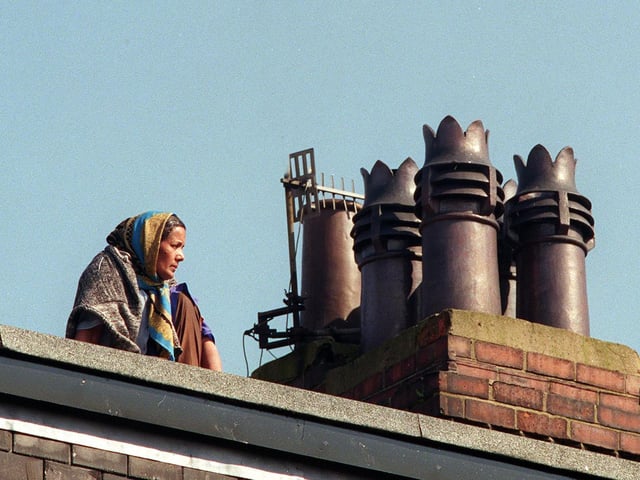 Roof top protest: This is Shakia Begum sat on her neighbours dormer roof after council officials tried to evict her from her Burley home.