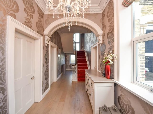 The spacious entrance hallway with staircase up, and rooms leading off.