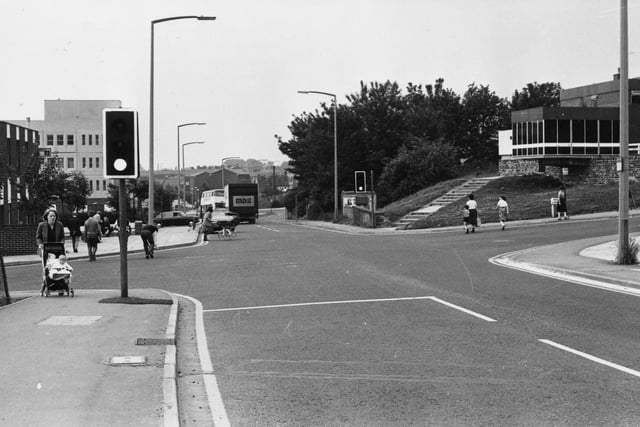 The crossroads on Bramley Town Street pictured in July 1980, looking from Upper Town Street towards Lower Town Street, with Hough Lane on the right and Waterloo Lane on the left. The Lord Cardigan public house is seen on the right. The Midland Bank is on the left, with Bramley Shopping Centre beyond.