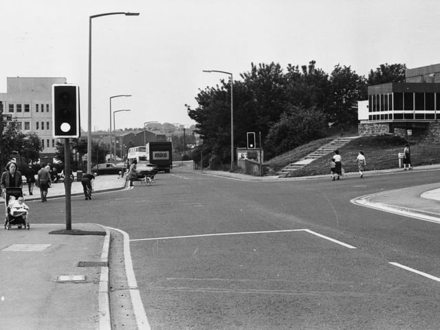 The crossroads on Bramley Town Street pictured in July 1980, looking from Upper Town Street towards Lower Town Street, with Hough Lane on the right and Waterloo Lane on the left. The Lord Cardigan public house is seen on the right. The Midland Bank is on the left, with Bramley Shopping Centre beyond.