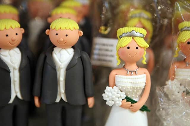 Wedding cake bride and groom figures are displayed for sale on July 10, 2007 in London. (Photo by Peter Macdiarmid/Getty Images)