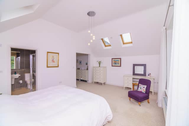 The primary bedroom suite offers a dressing area and en suite. This space offers lots of natural light due to the large windows and vaulted ceiling which features motorised Velux windows.