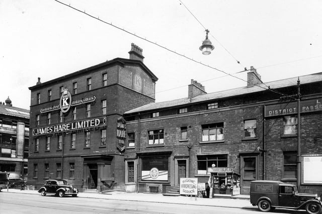The James Hare woollen warehouse on Wellington Street in June 1939. The cellar of number 68 has a sign for Hygenic Hairdressing Saloon and next to this a cigarette kiosk with a bored looking lady.