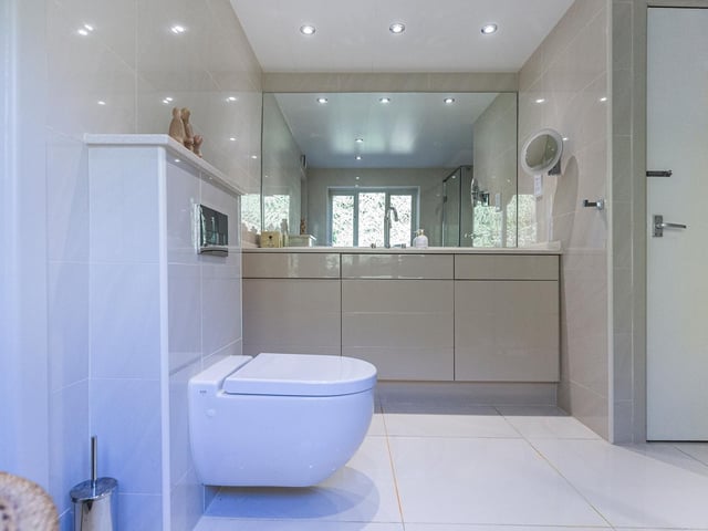 A wash basin within a high gloss vanity unit is a feature of the shower room.