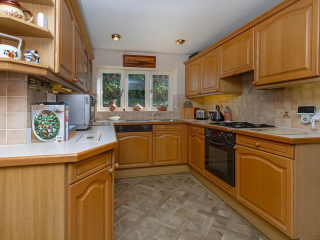 Integrated appliances within the kitchen include an oven, hob, and dishwasher.