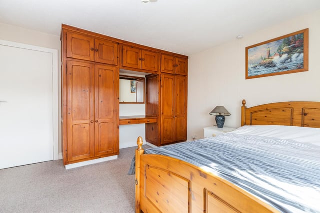 This double bedroom includes fitted wardrobes and cupboard units.