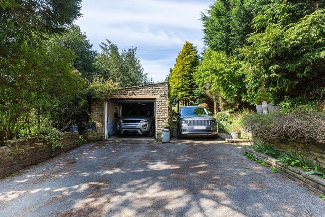 A gated driveway leads to the garage and additional parking spaces.