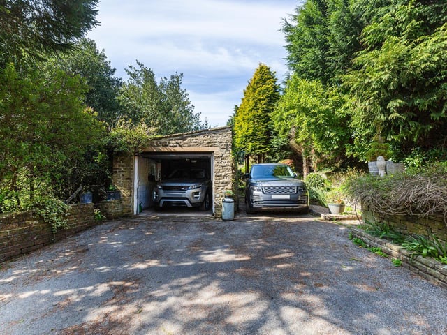 A gated driveway leads to the garage and additional parking spaces.