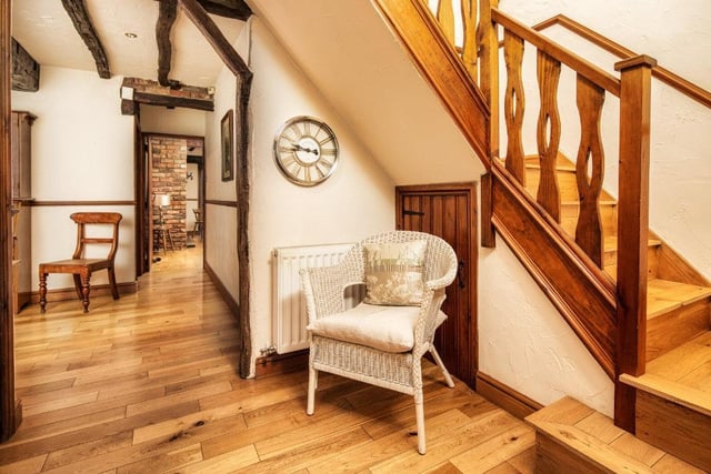 A wooden angled staircase leads up to the first floor from the hallway.