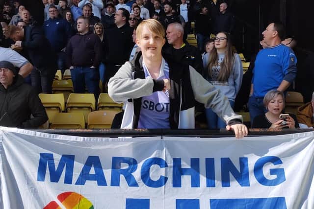 SALUTE: Marching Out Together Vice Chair Maz Ferguson poses with the group's flag at Vicarage Road (Pic: Marching Out Together)