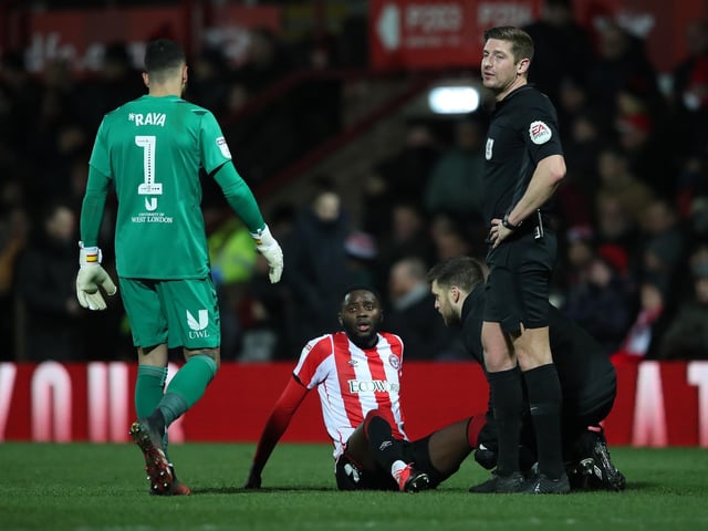 Brentford's Josh Dasilva receives treatment for an injury.