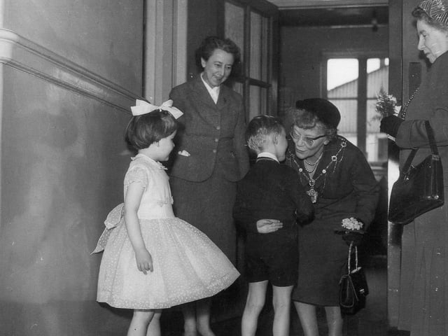 Pictured are two children presenting bouquets of flowers to the Lord Mayor's consort.