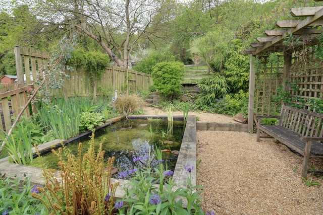 A good size pond is a feature within the garden, with seating close by.