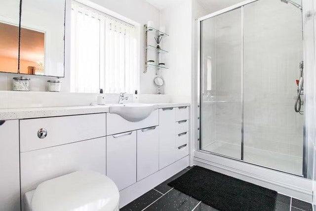 The main bathroom features a large shower and plenty storage space.