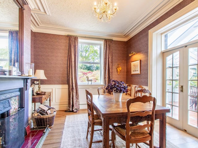 A slate surround to an open fire in the part-panelled dining room.