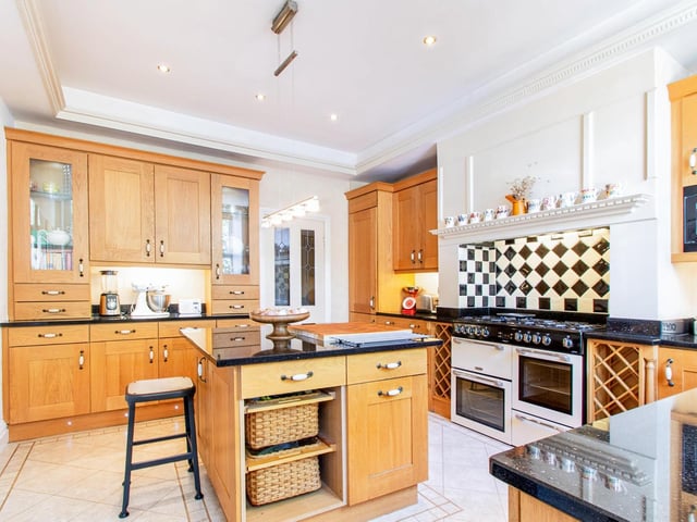 The swish breakfast kitchen with wooden units and central island.