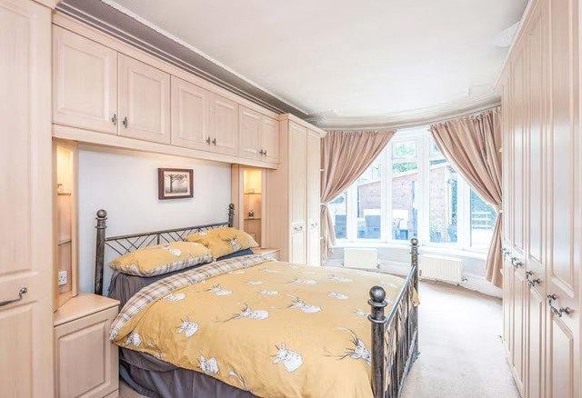 The master bedroom offers a stunning curved design with built in storage cupboards.