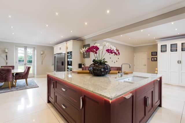 The kitchen includes a large central island and has large porcelain tiles with under floor heating.