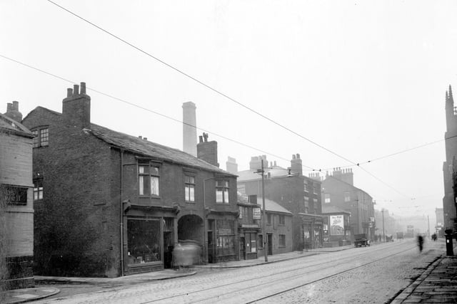 Meadow Lane in February 1937. Pictured, from the left, junction with New Lane, then Harry Briggs, greengrocer. The archway is the entrance to Holroyds Yard, then John Briggs, furniture shop.