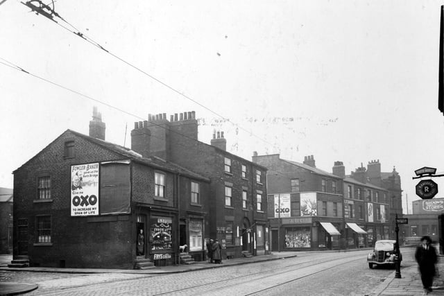 On the left, junction with Tabernacle Street, then Fred Stringer confectioner, next is Alex Pearson fish and chip shop. James Batchelor has a barbers shop  and George Sadgwick general store. Next street junction is Mill Street. On the right, a hanging sign for the 'White House' public house,