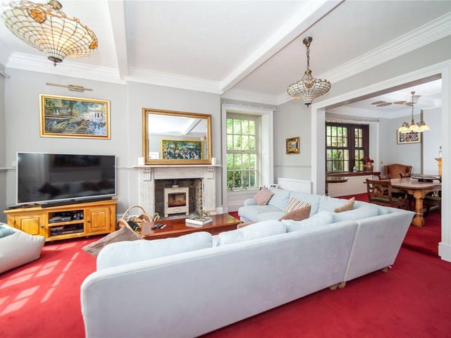 A feature fireplace with stove is central to this well lit room.