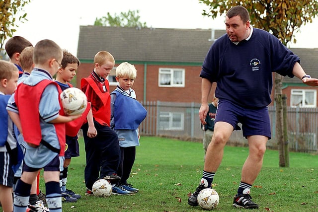 Armley Juniors listen to football coach Gerard Wilson during a training session at West Leeds High School in October 1999.