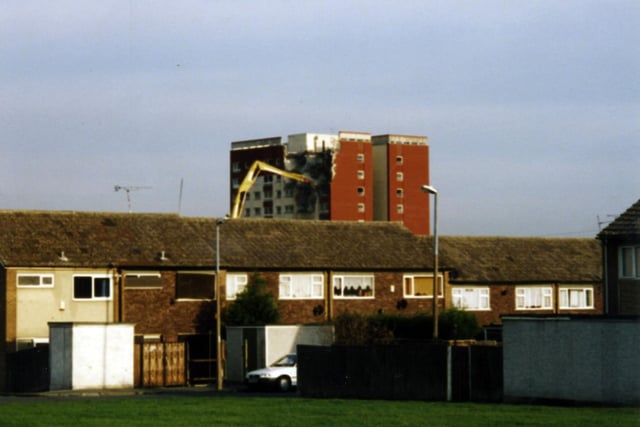 Demolition under way of the high-rise flats of Ash Tree Grange, with a crane taking apart the top storeys of this 12-storey building, located  off Swarcliffe Avenue. In the foreground are houses on Ash Tree Bank, also now demolished.