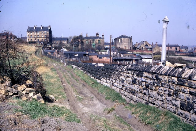 This scene, taken in  April 1968, from the path leading towards the railway, shows Victoria Place on the left and Springwell House, with green woodwork, in the centre. To the right of Springwell House, Back Green Methodist Church can be seen. All of these buildings are now demolished except for the church which has been converted to flats.