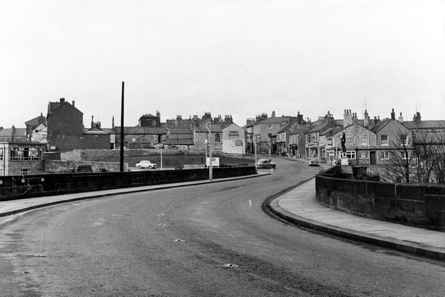 High Street from the bridge in February 1962. Also showing is the telephone pole put up in 1910 and the War Memorial which was unveiled in 1922. The area behind the pole was once known as Bishopgate but is now Bridge Foot. The Snack Bar and Bus Station, built in 1960, are to the left.