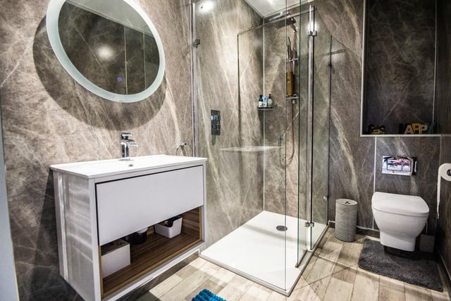 This contemporary style shower room includes a wash basin vanity unit and shower cubicle.