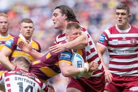 Huddersfield's Luke Yates is tackled by Wigan's Liam Byrne and Morgan Smithies. Picture by Allan McKenzie/SWpix.com.
