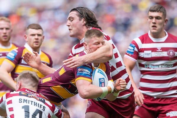 Huddersfield's Luke Yates is tackled by Wigan's Liam Byrne and Morgan Smithies. Picture by Allan McKenzie/SWpix.com.