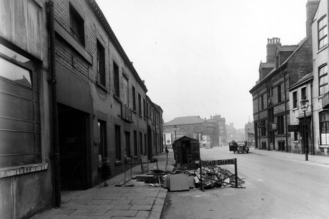 Roadworks on Hunslet Road leading up to the junction with South Brook Street in March 1950. A workman stands in a hut by "road closed" signs and a cordoned off hole.