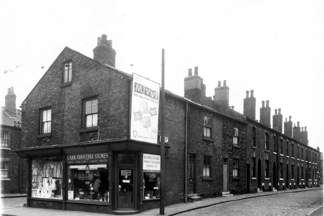 This photo shows one corner of Wainwirght Street and Balm Road in April 1959. The two shops to the right are on Balm Road. To the left, is a drapers with a window display full of children's clothes and next door is Carr Furniture Stores, also offering repairs and French polishing.