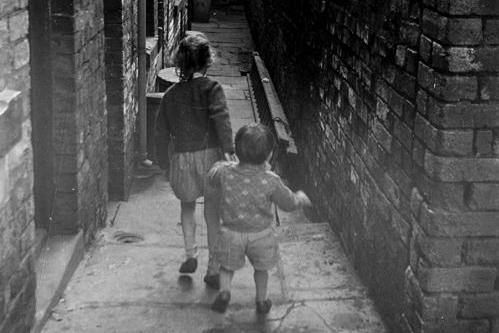 A view along a ginnel leading to Back Barker Square. Two children are in the foreground.